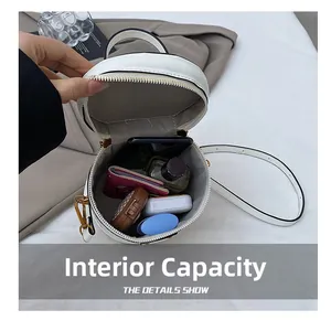 Internal capacity of the round bucket bag showing storage for phone and cosmetics