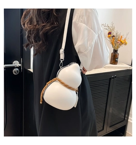 Close-up of a creative gourd-shaped crossbody bag in off-white faux leather with woven details