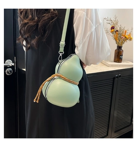 Détail du sac bandoulière vert clair en forme de gourde avec fermeture éclair et cordon