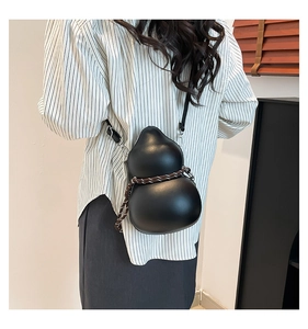 Détail macro d'un sac à bandoulière noir en forme de Wu Lou avec corde tressée et cuir mat