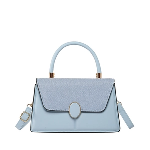Minimalist light blue handbag with woven texture flap and golden hardware on white background