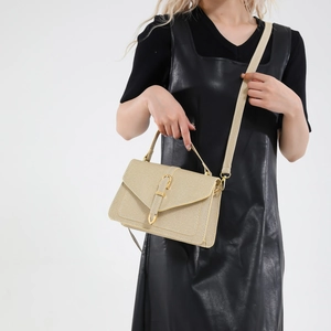 Elegant champagne gold woven crossbody bag with metal buckle shown on a model