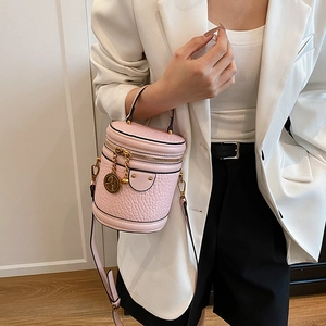 Pink cylinder bucket bag with textured leather detail and adjustable shoulder strap