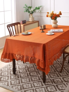 Detail of orange bohemian tablecloth with elegant lace ruffles and knit texture