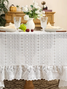 Detail of white vintage lace tablecloth featuring hollow embroidery and elegant ruffled edges