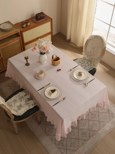 Close-up of pink lace tablecloth with elegant floral embroidery and ruffled edges