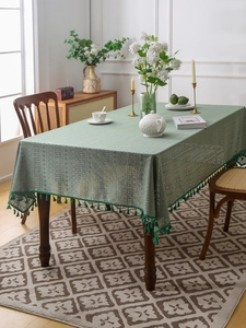 Dettaglio tovaglia in pizzo verde chiaro con eleganti frange e trama a maglia traforata