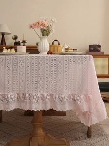 Detailed view of pink lace tablecloth with delicate hollow patterns and ruffled edges