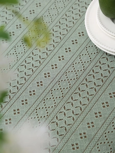 Dettaglio di tovaglia in pizzo all'uncinetto verde menta con motivi geometrici