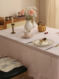 Detail of pink hollow-out lace tablecloth with romantic wavy edges and floral patterns