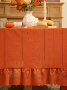 Detailed knit texture and lace edge of a caramel retro tablecloth with floral patterns