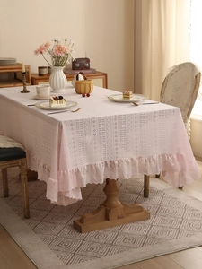 Close-up of pink lace tablecloth featuring intricate hollow-out floral patterns and ruffles