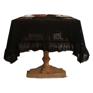 Elegant black lace tablecloth with vintage hollow patterns on a rustic wooden table