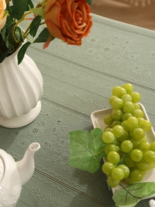 Detail of green lace tablecloth with intricate floral weave and elegant home decor