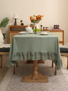 Detailed view of the vertical hollow lace and eyelash fringe on this green tablecloth