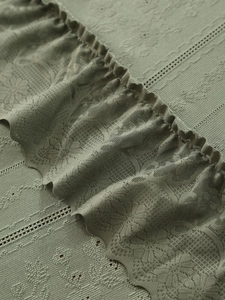 Macro detail of Nordic lace trim on a sage green retro luxury heat-resistant tablecloth
