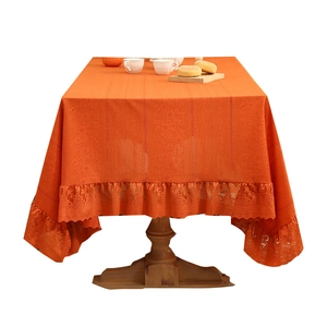 Orange Nordic tablecloth with elegant lace ruffles and jacquard texture on wooden table