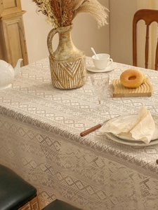 Detailed macro view of cream lace tablecloth with vintage hollow diamond pattern texture