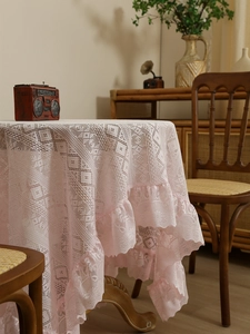 Detail of light pink vintage lace tablecloth featuring double-layered ruffled edges