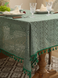 Detail of vintage green lace tablecloth with crochet patterns and elegant tassel edges