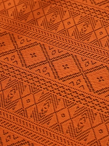 Detailed macro shot of burnt orange geometric hollow lace crochet tablecloth pattern