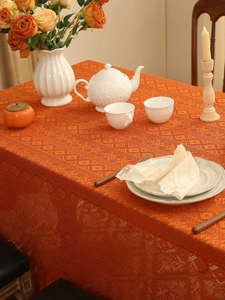 Detail of orange lace tablecloth with hollow diamond pattern and knitted texture