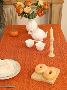 Close-up of terracotta lace tablecloth with geometric patterns and fringe edges