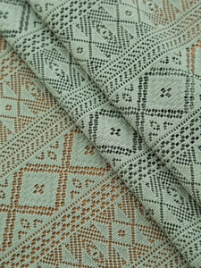 Close-up of light green hollow lace tablecloth with geometric diamond knit patterns