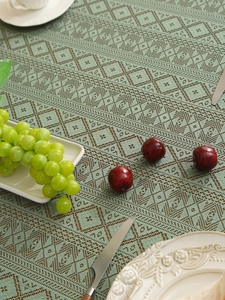 Close-up of thick woven tablecloth with green and brown geometric texture and pattern