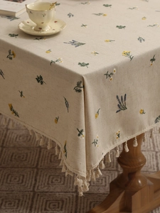 Detail of floral embroidery and cream tassels on a premium linen blend tablecloth