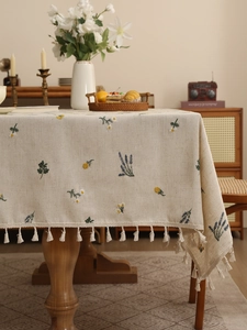 Detail of premium linen tablecloth with lavender floral embroidery and ivory tassels