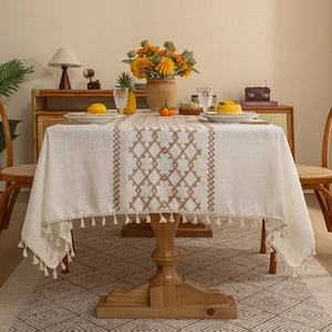 Linen tablecloth with diamond embroidery and elegant brown tassels in a home setting