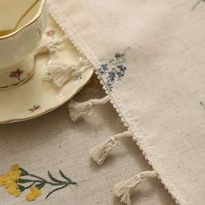 Linen embroidered tablecloth with floral patterns and delicate fringe trim edges