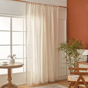 Detailed macro view of vintage cream lace curtain with geometric patterns and beige tassels