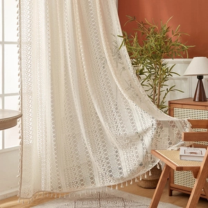Vintage American boho lace curtain in creamy white with elegant fringe and crochet patterns