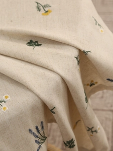Close-up of premium linen tablecloth featuring delicate floral embroidery and texture