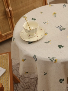 Close-up of floral embroidery on premium linen tablecloth with delicate daisies and lavender