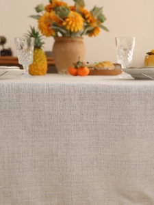 Close-up of beige linen tablecloth showing premium woven texture and natural draping fabric