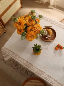 Close-up of oatmeal linen tablecloth with brown diamond patterns in a cozy dining setting