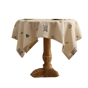 Round linen tablecloth with embroidered lavender and daisy flowers on a rustic wooden table