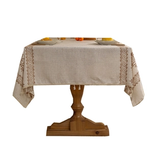 Linen textured oatmeal tablecloth with brown geometric embroidery and white tassels