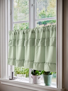 Close-up of light green tiered ruffled coffee curtain with three layers of draped fabric