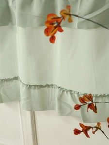 Detail of light green ruffled chiffon fabric tiers with delicate stitching for cafe curtains