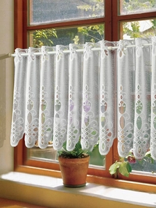 Detail of white lace cafe curtain with floral hollow patterns and rod pocket design