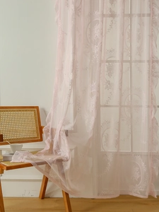 Detail of pink French lace curtain with vintage floral embroidery and scalloped edges