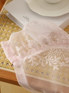 Detail of light pink floral lace curtain fabric with elegant mesh embroidery texture