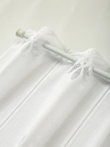 Close-up of white lace kitchen cafe curtain featuring striped texture and rod pocket design
