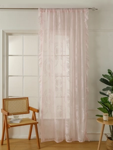 Close-up of pink lace sheer curtain with floral embroidery and ruffle trim detail