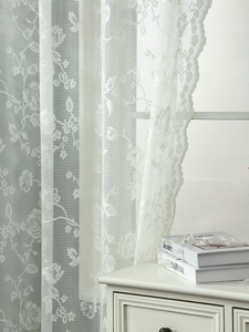 Detailed view of white French floral lace curtain with delicate scalloped edges and mesh