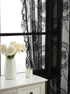 Close-up of black floral lace curtain showing intricate patterns and elegant home decor